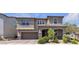Two-story home with a two-car garage, landscaped front yard and covered porch with stone accents at 6370 Ava Ridge Ave, Las Vegas, NV 89141