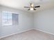 Well-lit bedroom with fan, window, and neutral carpet at 700 Red Bark Ln, Henderson, NV 89011