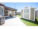 Home's backyard with patio, artificial turf, and a storage shed under sunny skies at 7231 Sequoia Springs Dr, Las Vegas, NV 89147