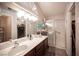 Bright bathroom with dual sinks, large mirrors, and walk-in shower with glass door at 7231 Sequoia Springs Dr, Las Vegas, NV 89147