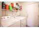 Functional laundry room with washer, dryer, and shelving for storage at 7231 Sequoia Springs Dr, Las Vegas, NV 89147