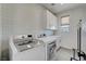 Well-appointed laundry room with modern washer and dryer, ample storage, and stylish patterned wallpaper at 734 Glowing Horizon St, Henderson, NV 89052