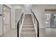 Elegant staircase with modern railing, carpeted steps, and abundant natural light filtering into the entryway at 734 Glowing Horizon St, Henderson, NV 89052