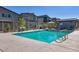 Community pool with a fenced surround, lounge chairs, and nearby picnic tables at 7472 Brody Meadows St, North Las Vegas, NV 89084