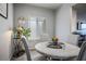 Cozy dining area features neutral colors, a round table with upholstered chairs, and lots of natural light at 7472 Brody Meadows St, North Las Vegas, NV 89084
