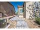 A paved walkway passes between two homes. A small desert-landscaped yard sits to the right at 7472 Brody Meadows St, North Las Vegas, NV 89084