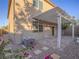 Charming backyard with a pergola covered patio, gravel landscaping, and pink flowers creating a tranquil outdoor space at 7605 Lake Fork Peak St, Las Vegas, NV 89166