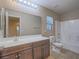 Well-lit bathroom featuring a vanity with a large mirror and a shower-tub combo at 7605 Lake Fork Peak St, Las Vegas, NV 89166