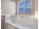 Close-up of a white soaking bathtub with chrome fixtures and a window at 7605 Lake Fork Peak St, Las Vegas, NV 89166