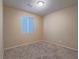 Neutral bedroom featuring plush carpet, a window, and simple light fixture at 7605 Lake Fork Peak St, Las Vegas, NV 89166