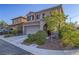 Desert landscaped two-story home with a two-car garage, a covered front porch, and neutral paint at 7605 Lake Fork Peak St, Las Vegas, NV 89166
