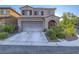 Two-story home with desert landscaping, an attached two-car garage, and a covered front porch at 7605 Lake Fork Peak St, Las Vegas, NV 89166