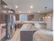 Open kitchen with stainless appliances, granite countertops, and island seating at 7605 Lake Fork Peak St, Las Vegas, NV 89166