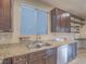 Kitchen featuring granite countertops, a stainless dishwasher, and built-in shelving at 7605 Lake Fork Peak St, Las Vegas, NV 89166