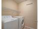 A functional laundry room features a washer, dryer, and wire shelving for organized storage solutions at 7605 Lake Fork Peak St, Las Vegas, NV 89166