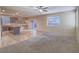 Inviting living room open to kitchen, featuring tile and carpet flooring, ceiling fan, and ample natural light at 7605 Lake Fork Peak St, Las Vegas, NV 89166