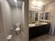 Bright bathroom featuring dual sinks, granite countertop, vanity and updated fixtures at 7636 Bandon Cliffs St, North Las Vegas, NV 89084