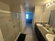 Spacious bathroom with granite double vanity, glass door shower, and neutral tile flooring at 7636 Bandon Cliffs St, North Las Vegas, NV 89084