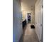 Hallway view of ensuite bathroom leading to walk-in closet, with double doors and ceramic floors at 7636 Bandon Cliffs St, North Las Vegas, NV 89084