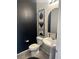 Stylish powder room with modern fixtures and elegant black accent wall at 7636 Bandon Cliffs St, North Las Vegas, NV 89084