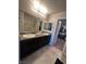 Bright bathroom featuring a double vanity with granite countertop and a walk-in closet at 7636 Bandon Cliffs St, North Las Vegas, NV 89084