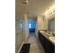 Spacious bathroom with granite double vanity, glass door shower, and neutral tile flooring at 7636 Bandon Cliffs St, North Las Vegas, NV 89084