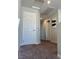 Hallway with gray walls and brown carpet, featuring a white door and artwork at 7636 Bandon Cliffs St, North Las Vegas, NV 89084