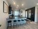 Modern kitchen featuring dark cabinetry, granite countertops, and a spacious island with bar stools at 7636 Bandon Cliffs St, North Las Vegas, NV 89084