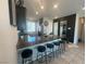 Modern kitchen featuring dark cabinetry, granite countertops, and a spacious island with bar stools at 7636 Bandon Cliffs St, North Las Vegas, NV 89084