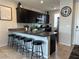 Modern kitchen featuring dark cabinetry, granite countertops, and a spacious island with bar stools at 7636 Bandon Cliffs St, North Las Vegas, NV 89084