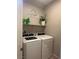 Modern laundry room with updated appliances including a washer and dryer and storage shelf at 7636 Bandon Cliffs St, North Las Vegas, NV 89084