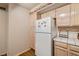Bright kitchen featuring light wood cabinets, white appliances, and tile countertops at 7950 W Flamingo Rd # 1024, Las Vegas, NV 89147