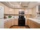 Charming kitchen with light wood cabinets, black appliances and tile countertops at 7950 W Flamingo Rd # 1024, Las Vegas, NV 89147