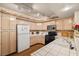 Traditional kitchen with light wood cabinets, white appliances, and tile countertops at 7950 W Flamingo Rd # 1024, Las Vegas, NV 89147