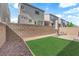 Backyard features a small patch of artificial turf and a stone perimeter at 8072 Haywood Estate, Las Vegas, NV 89113