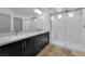 Modern bathroom features a double vanity, large mirror, and a glass-enclosed shower at 8072 Haywood Estate, Las Vegas, NV 89113