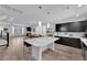 Open-concept kitchen with a large island, dark cabinets, and stainless steel appliances, flowing into the dining area at 8072 Haywood Estate, Las Vegas, NV 89113