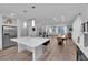Open-concept kitchen, island with seating, flowing into living and dining area, featuring stainless steel appliances at 8072 Haywood Estate, Las Vegas, NV 89113