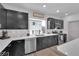 Modern kitchen with stainless steel appliances, quartz countertops, dark cabinets, and decorative backsplash at 8072 Haywood Estate, Las Vegas, NV 89113