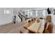 Bright living room featuring hardwood floors, neutral walls, modern stairs, and a dining area in an open-concept space at 8072 Haywood Estate, Las Vegas, NV 89113