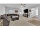 Open-concept living room with large sectional, entertainment center, and natural light at 8072 Haywood Estate, Las Vegas, NV 89113