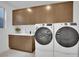 Well-equipped laundry room with front-load washer and dryer, ample counter space, and sleek upper cabinets at 818 Calluna St, Las Vegas, NV 89138