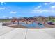 A colorful playground with climbing structures, slides, and interactive elements under a bright blue sky with fluffy white clouds at 818 Calluna St, Las Vegas, NV 89138