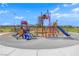 Bright and inviting playground with modern equipment, slides, and climbing structures, set against a mountain backdrop at 818 Calluna St, Las Vegas, NV 89138