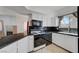 Modern kitchen with sleek black appliances, white cabinetry, and granite countertops at 900 Heavenly Hills Ct # 114, Las Vegas, NV 89145
