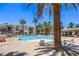 A luxurious community pool surrounded by palm trees and comfortable lounge chairs at 9050 W Warm Springs Rd # 2062, Las Vegas, NV 89148