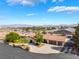 Expansive aerial view of desert home with tile roof, lush landscaping, and mountain views at 9385 Mohawk St, Las Vegas, NV 89139