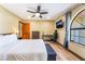 Bright bedroom with wood floors, ceiling fan, large arched window, and desk area at 9385 Mohawk St, Las Vegas, NV 89139