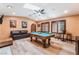Spacious game room with a pool table, leather couch, fireplace and wood flooring at 9385 Mohawk St, Las Vegas, NV 89139