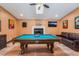 Spacious game room with a pool table, leather couch, fireplace and wood flooring at 9385 Mohawk St, Las Vegas, NV 89139